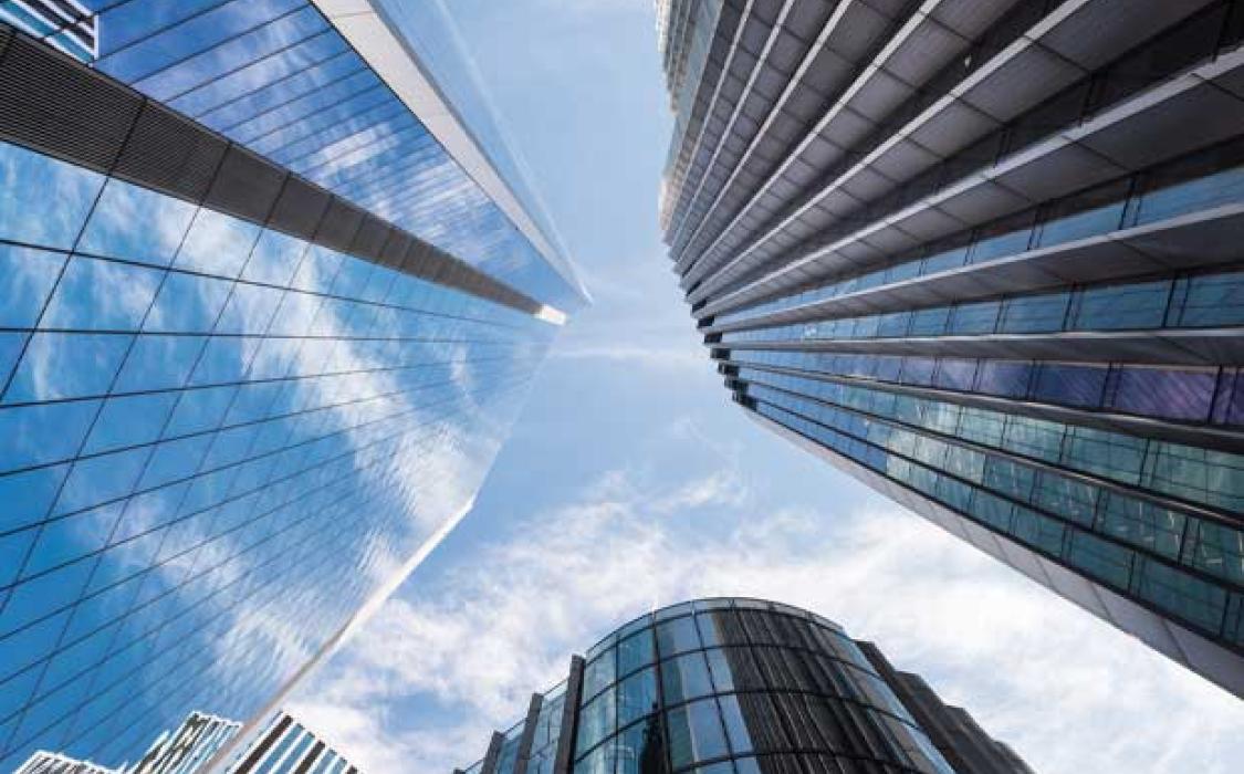 A view of tall skyscraper buildings against a blue sky